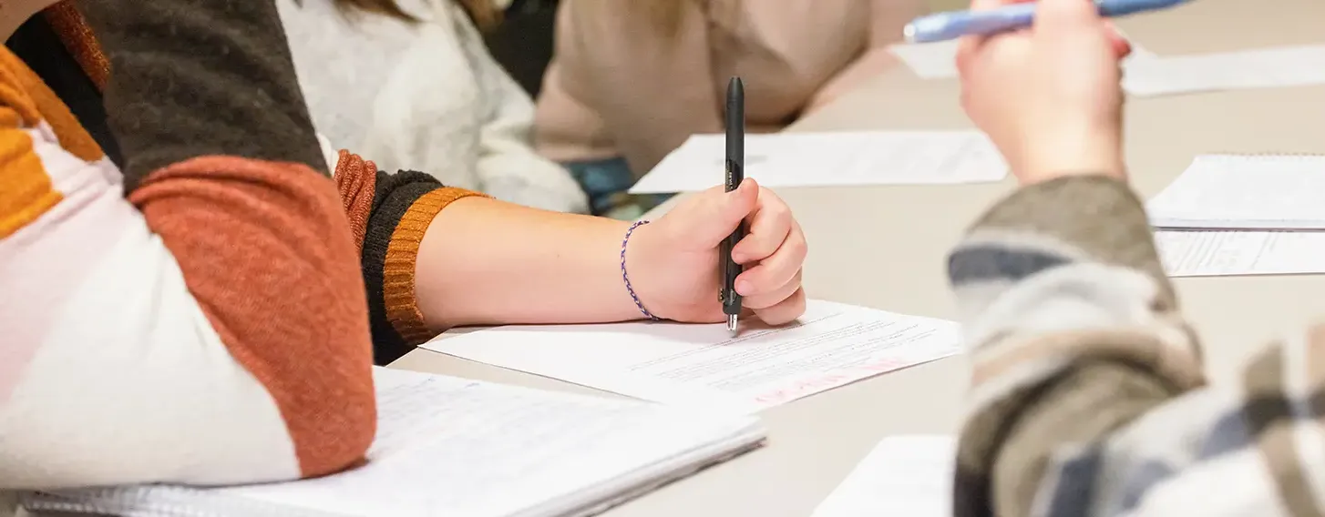 A group of students writing at a table